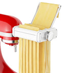 White 3-in-1 pasta attachment on red stand mixer rolling a sheet and cutting noodles